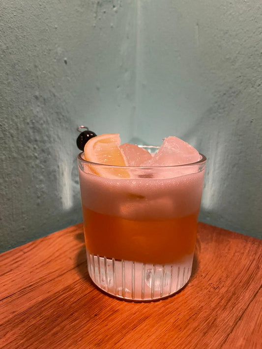 Image of a Whisky Sour cocktail garnished with a cherry and lemon slice: Whisky Sour cocktail recipe with a cherry and lemon garnish.